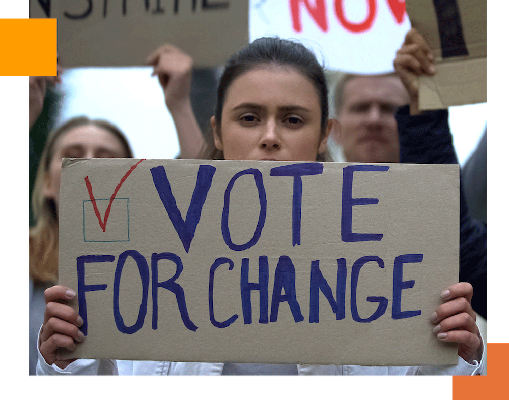 woman holding a sign that reads vote for change